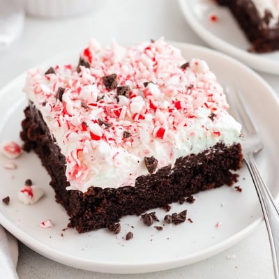 Sliced Peppermint Poke Cake showing chocolate sponge, mint pudding pockets